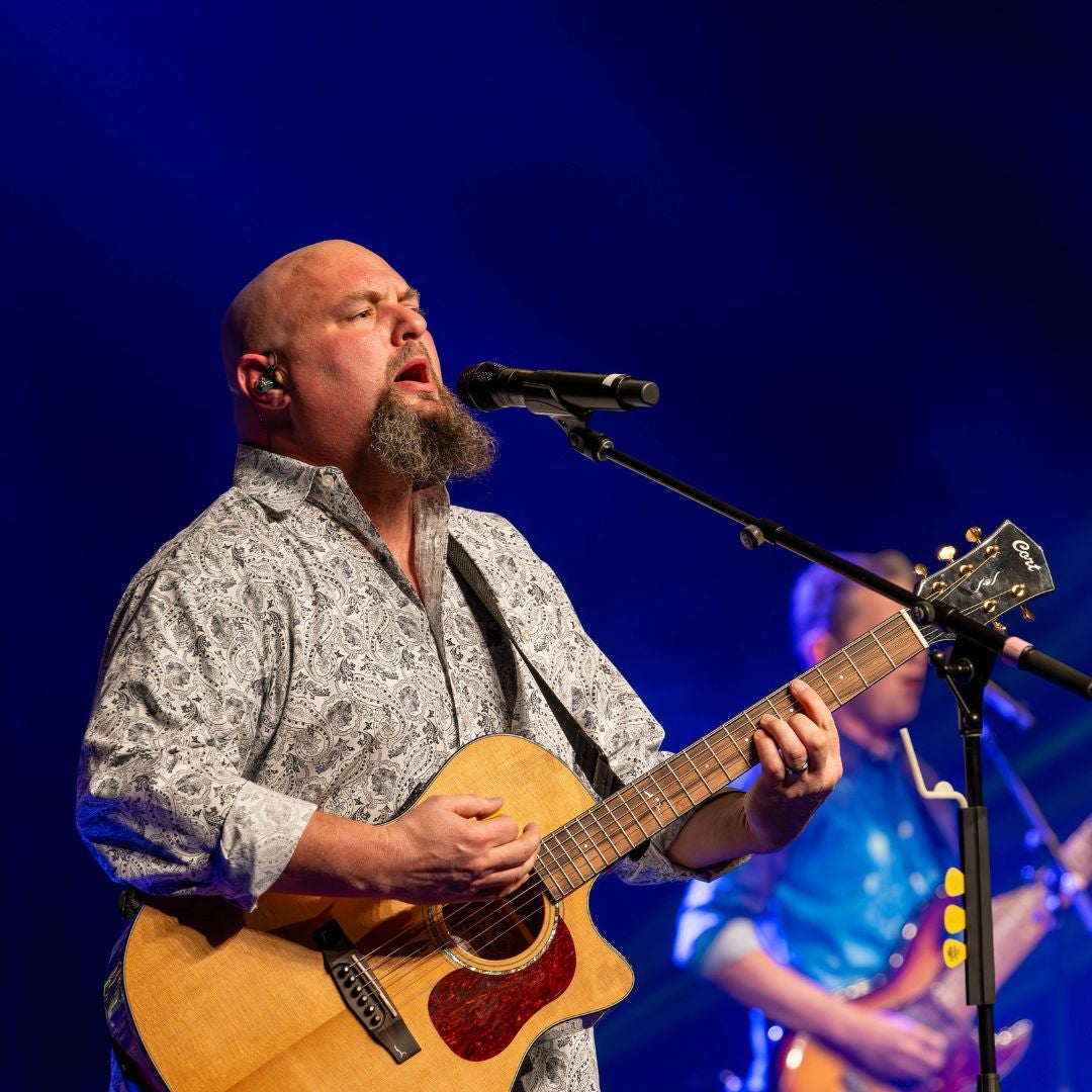 a man playing guitar on stage